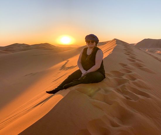 Jennifer assise sur une dune de sable dans le désert du Sahara près de Merzouga au Maroc