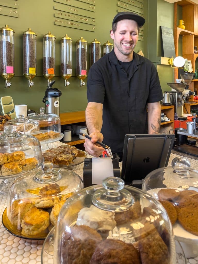 Evan à la caisse du Café Chapeau Moustache